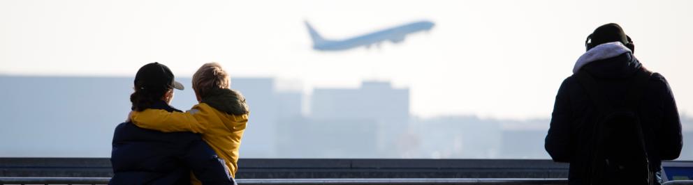 Mensen kijken naar opstijgend vliegtuig op Schiphol (foto vliegtuiggeluid.nl)